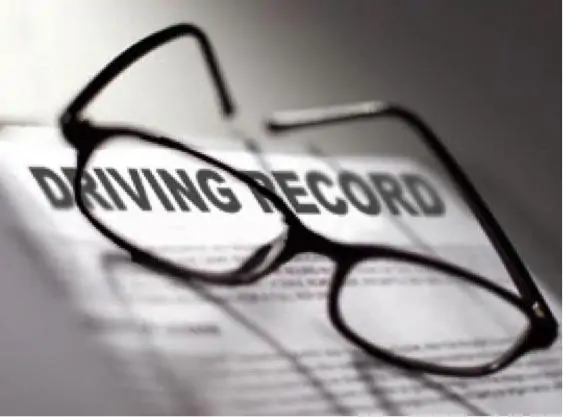 Close up of a driving record document with glasses, illustrating driver history verification for insurance